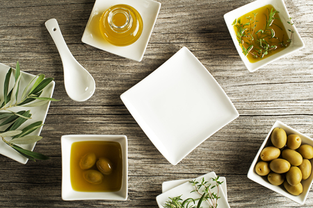 Olive oil with fresh herbs on wooden backgroundの写真素材