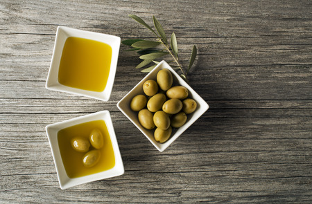 Olive oil with fresh olives on wooden backgroundの写真素材