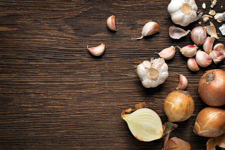 Garlic cloves and onions on wooden vintage backgroundの写真素材