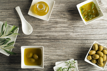 Olive oil with fresh herbs on wooden backgroundの写真素材