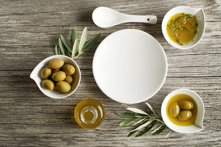 Olive oil with fresh herbs on wooden backgroundの写真素材