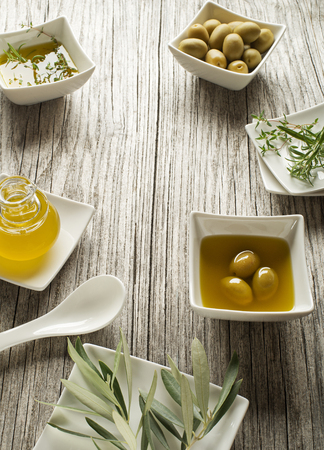 Olive oil with fresh herbs on wooden backgroundの写真素材