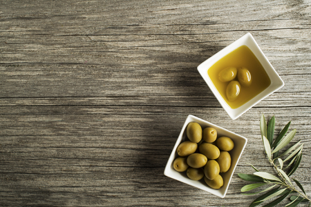 Olive oil with fresh olive fruit on wooden background.の写真素材