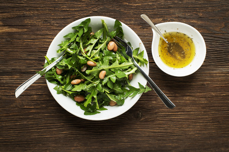 Fresh dandelion salad with beans on wooden backgroundの写真素材