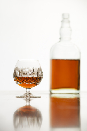 Cognac in glass and bottle on white backgroundの写真素材