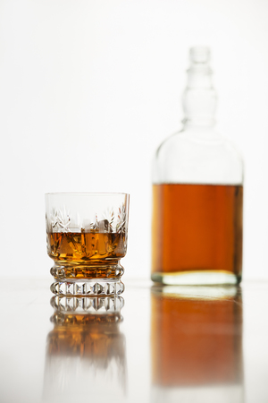 Whiskey glass with bottle on white background.の写真素材