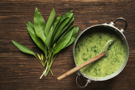 Fresh healthy green soup on wooden background overhead shoot.の写真素材