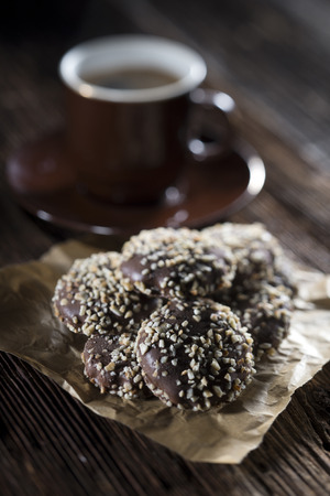 Cookies covered with chocolate and nuts. With cup of coffee on dark background.の写真素材