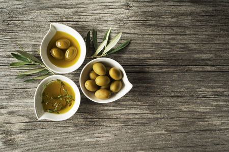 Olive oil with fresh herbs on wooden backgroundの写真素材
