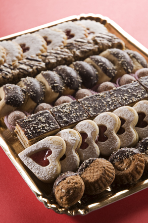 Plate with tasty Christmas cookies on red tableの写真素材