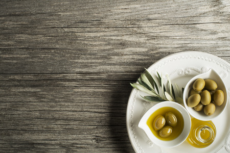 Olive oil with fresh olive fruits on wooden backgroundの写真素材