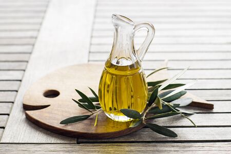Olive oil with branch on the wooden tableの写真素材