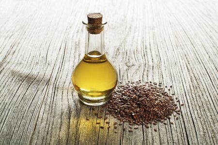 Linseed oil with seeds on wooden backgroundの写真素材