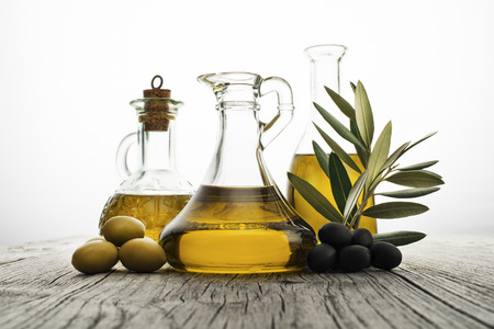 Olive oil with branch on the wooden backgroundの写真素材