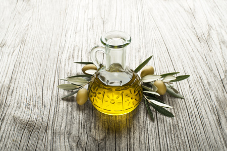Olive oil with branch on the wooden backgroundの写真素材