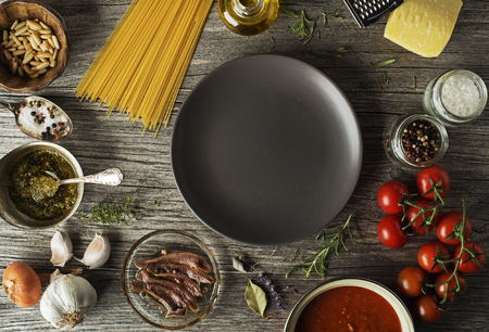 Spaghetti with ingredients for cooking pasta on wooden backgroundの写真素材
