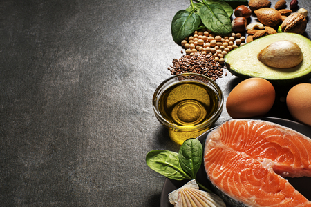 Selection of healthy food. Raw steak of salmon with fresh ingredients on gray background.の写真素材