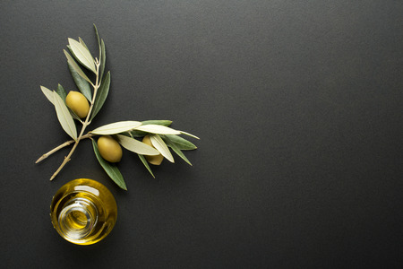Olive oil and olive branch on black backgroundの写真素材