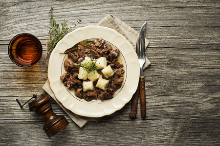 Fresh fried chicken liver with onion and gnocchi on wooden tableの写真素材