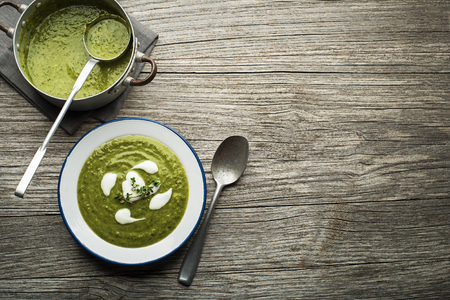 Fresh healthy green soup on wooden background overhead shoot.の写真素材