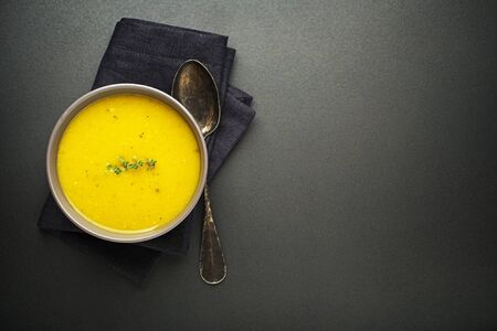 Healthy vegetable cream soup with herbs on dark background Top viewの写真素材