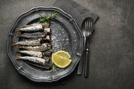 Fried sardines with salt and herbs on rustic backgroundの写真素材