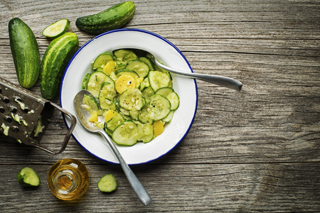 Fresh cucumber salad with potatoes on wooden backgroundの写真素材