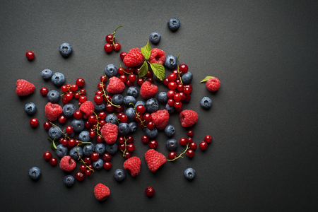 Bowl of fresh mixed berries on black backgroundの写真素材