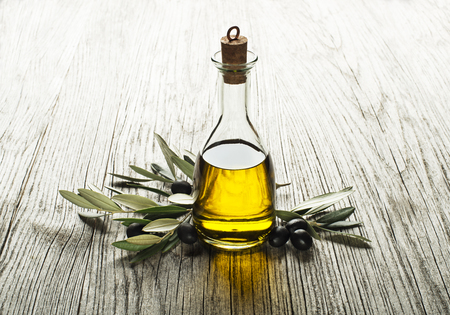Olive oil and olive branch on a wooden backgroundの写真素材