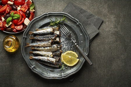 Fried sardines with salt and herbs on rustic backgroundの写真素材