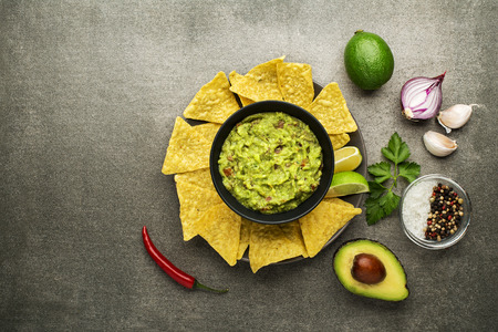 Guacamole sauce with fresh ingredients and corn nachos chipsの写真素材