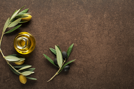 Olive oil and olive branch on brown backgroundの写真素材