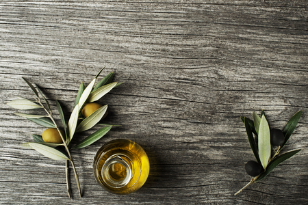 Olive oil and olive branch on a wooden backgroundの写真素材