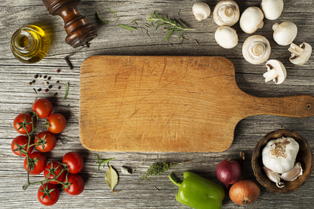 Mushrooms champignons and tomatoes with fresh ingredients on wooden backgroundの写真素材