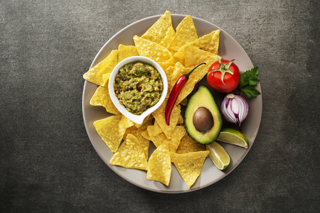 Guacamole sauce with fresh ingredients and corn nachos chipsの写真素材