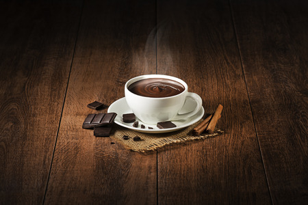 Cup of hot chocolate and cocoa with smoke on wooden background.の写真素材