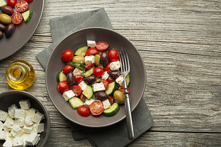Salad with cheese and fresh vegetables on wooden background. Greek salad.の写真素材