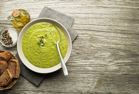 Fresh healthy green soup on wooden background overhead shoot.の写真素材