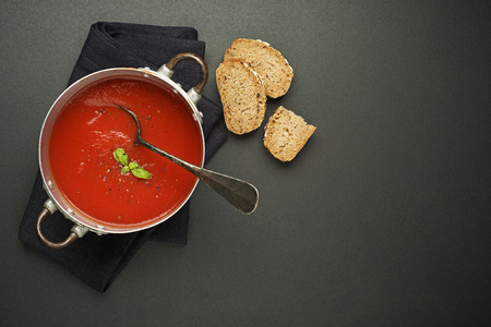 Fresh tomato soup with bread on black background. Top viewの写真素材