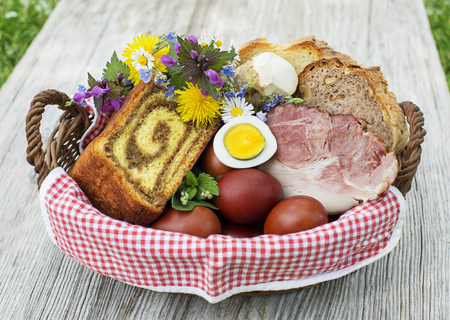 Easter traditional food with ham, eggs and bread in basket. Holidays background outdoorの写真素材