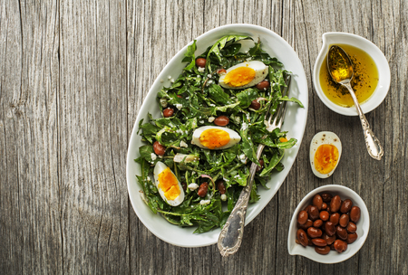 Fresh healthy dandelion salad with eggs and beans overhead shootの写真素材