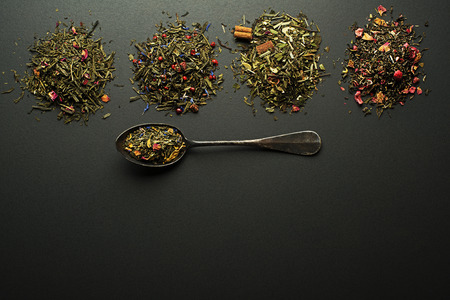 Dry tea collection and spices of different types on black backgroundの写真素材