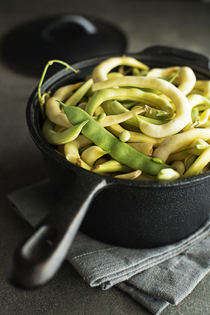 Cooked fresh green and yellow beans in black panの写真素材