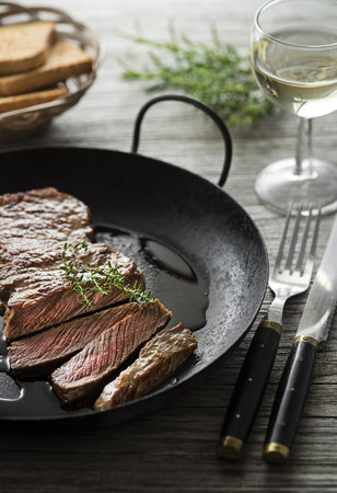 Grilled beef steaks with spices on wooden tableの写真素材