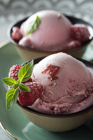 Homemade organic Raspberry ice cream scoops in bowlの写真素材
