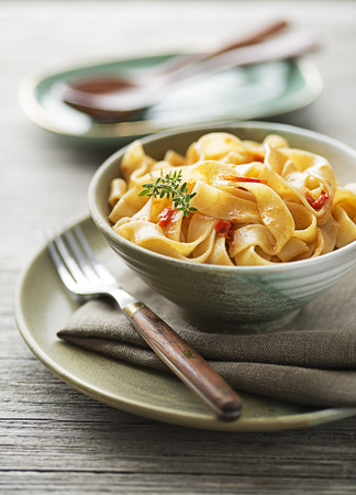Delicious meal with pasta fettuccine and tomato sauce served on wooden backgroundの写真素材