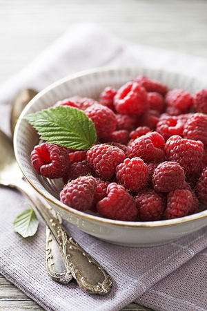 Raspberry berries with green leaf close up. Healthy food with fresh fruit.の写真素材