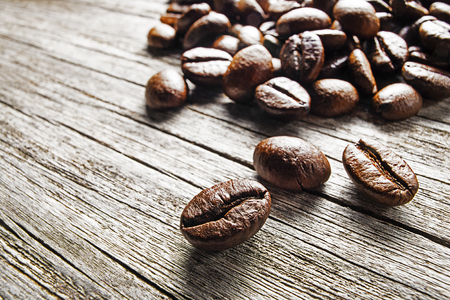 Roasted and brewed Coffee beans on wooden background close upの写真素材