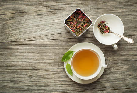 Cup of tea with dry green and herbs tea collection on wooden tableの写真素材