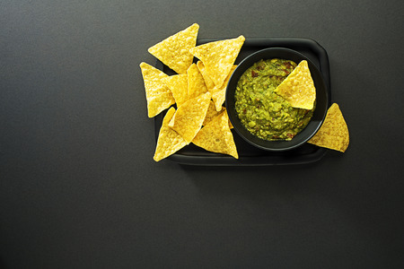Guacamole sauce with corn nachos chips on plateの写真素材